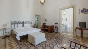 A bedroom with a bed, a desk, a chair, a television, and a patterned floor. - 3008 Dimora Donn`anna - Bilo 4 by Barbarhouse (Ortelle)