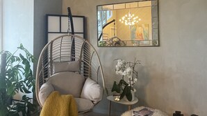 A modern living room with a hanging chair, a small table with a plant, and a mirror on the wall. - Exclusive & Elegant Frogner Apartment in the Heart of Oslo (Oslo)