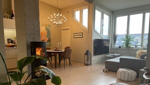 A modern living room with a fireplace, dining area, and large windows. - Exclusive & Elegant Frogner Apartment in the Heart of Oslo (Oslo)