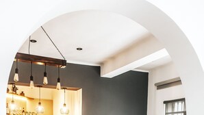 A modern interior with a dining area, a wooden cabinet, and a wall-mounted clock.