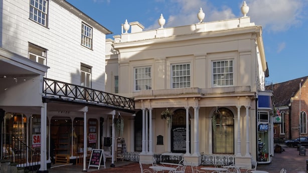 A historic building with a covered patio and outdoor seating area.