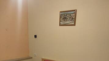 Un dormitorio con una cama, una mesita de noche, una lámpara y un cuadro en la pared.