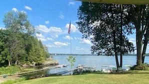 Eine Rasenfläche mit Blick auf einen See und Boote.
