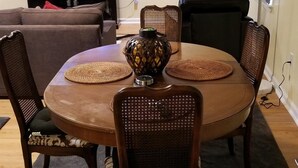 A dining area with a round table, six chairs, a decorative vase, a television, and a ceiling fan. - Close to Fort Eisenhower & Augusta Golf Course (Hephzibah)