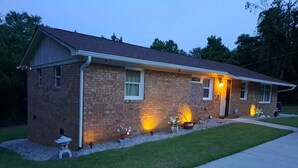 A two-story brick house with a sloped roof, a front porch, and a driveway. - Close to Fort Eisenhower & Augusta Golf Course (Hephzibah)