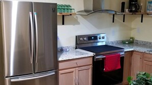 A modern kitchen with stainless steel appliances, a wooden countertop, and a black oven. - Close to Fort Eisenhower & Augusta Golf Course (Hephzibah)