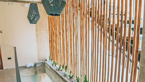 A staircase with a bamboo wall and plants, leading to a higher floor. - Eolia Sustainable Design Hotel (Manta)