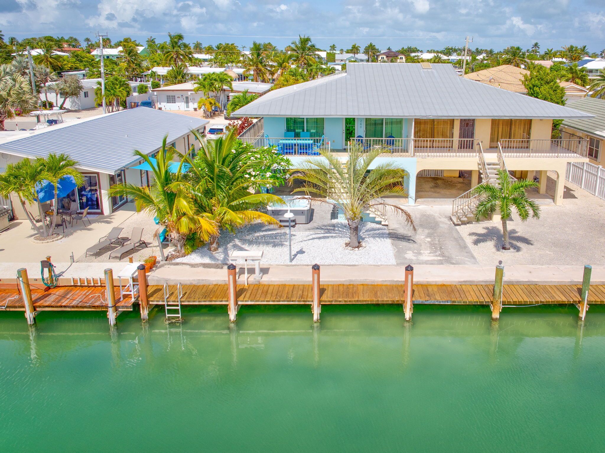 A resort with a pool, palm trees, and a building with a blue facade.