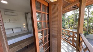 A room with a bed, a window, and a view of the outdoors. - Studios Aromas do Campeche - Floripa (Florianópolis)