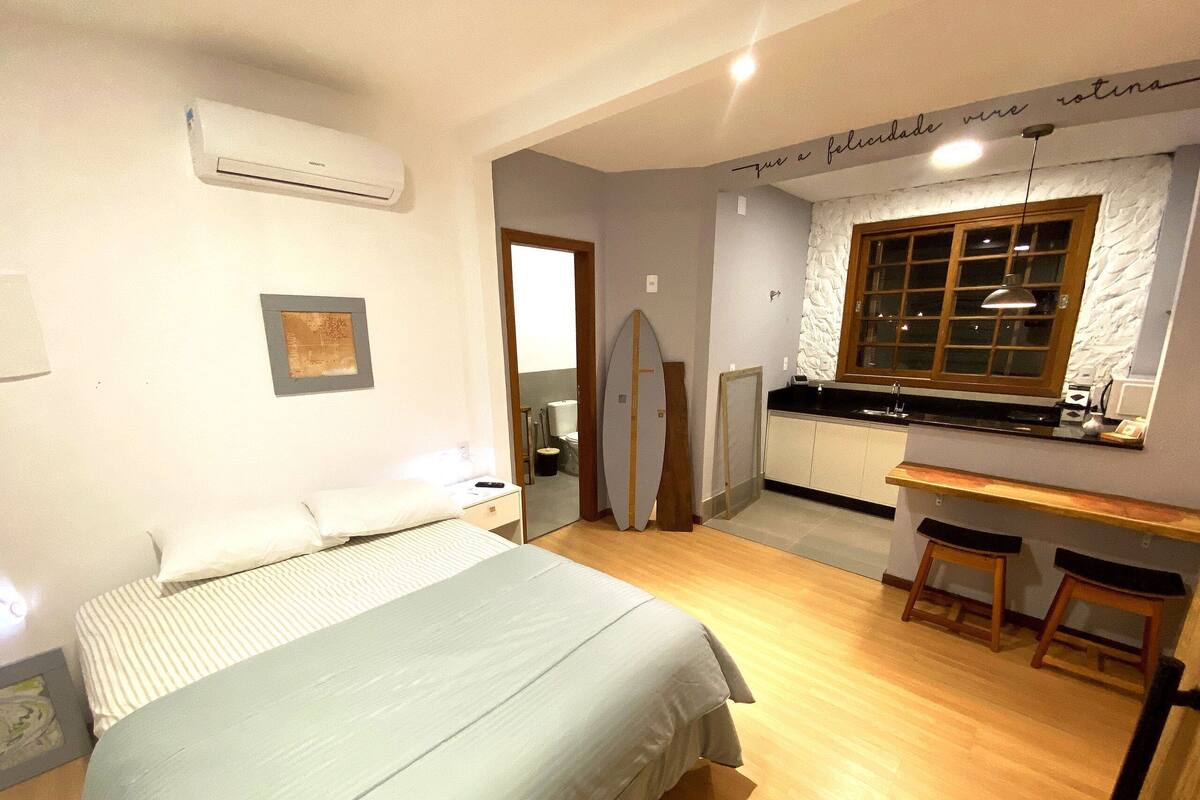 Une chambre à coucher comprenant un lit, une table de chevet et un appareil de climatisation.