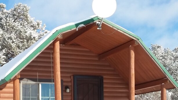 A log cabin with a porch, a window, and a door. - Comfy cabin for two close to Grand Canyon and many Northern Arizona attractions (Williams)