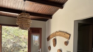 Une pièce dotée d’un plafond en bois, d’une porte donnant sur l’extérieur et d’un mur décoré dans un style rustique.