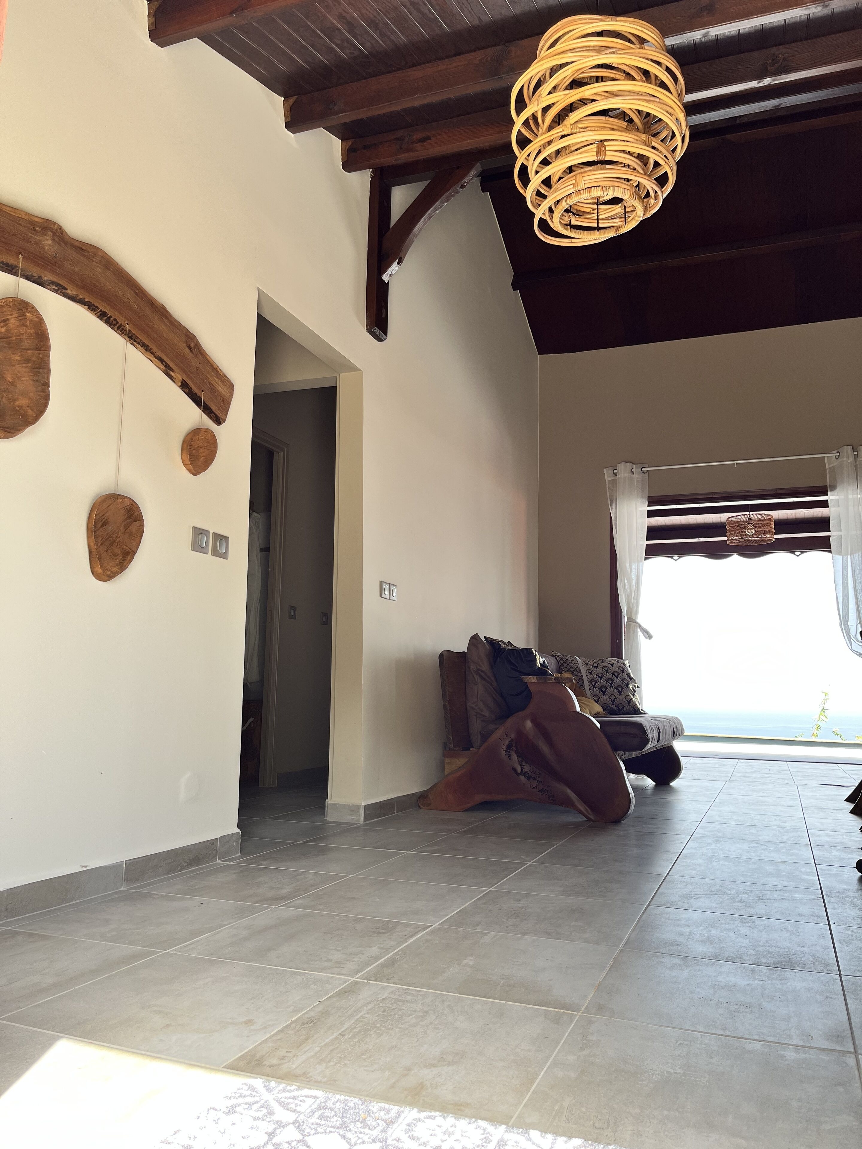 Un'ampia stanza con soffitto alto, una grande finestra con tende e un letto con vista.