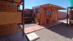 A small wooden structure with a sign indicating an emergency exit. - Yurak Apart Hotel (San Pedro de Atacama)