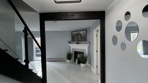 Ein modernes Interieur mit Treppe, Kamin und dekorativen Wandspiegeln.