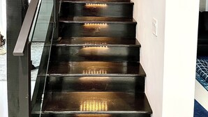 Eine Treppe mit Geländer und Beleuchtung entlang der Stufen.