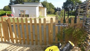 A fenced area with a wooden gate, a small building, and a sign that reads "GRAND CHIMNEY". - Le Grand Chemin - Ferel (FEREL)
