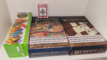 A collection of board games including Juggling Tower, Snakes and Ladders, and Rummy-O.