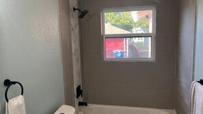 Tina con regadera, toallas, jabón, shampoo 