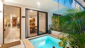 Uma casa moderna com piscina, portas de vidro deslizantes e uma área de jantar visível através das portas.