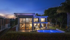 A modern two-story house with a swimming pool, large glass windows, and a well-maintained garden. - Pool, sun and sea view - Villa das Quebradas (Funchal)
