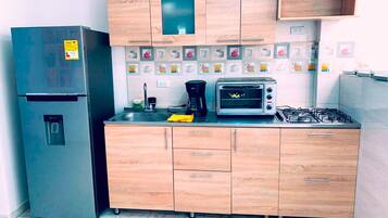 Full-sized fridge, oven, stovetop, cookware/dishes/utensils