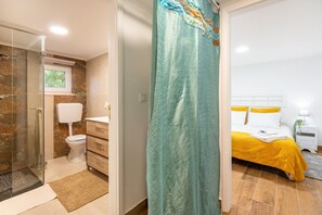 Une salle de bain avec une douche à parois de verre, des toilettes et un meuble-lavabo avec des tiroirs.