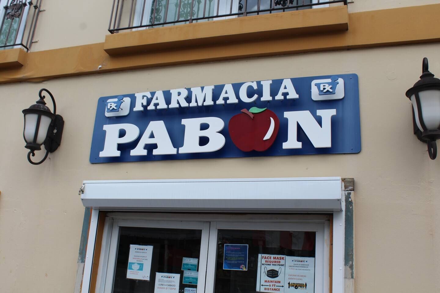 Una fachada con un letrero que dice 'FARMACIA PABON' y un símbolo de manzana.