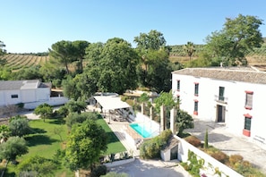 A residential area with a swimming pool, a covered patio, and a view of the surrounding landscape.