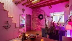 A cozy room with a brick wall, a round mirror, and a wooden ceiling. - Love island romantique rue carnot (Annecy)