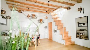 A modern interior with a wooden staircase, a dining area, and a kitchen. - Love island romantique rue carnot (Annecy)