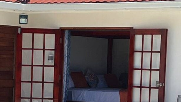 Ein Schlafzimmer am Pool mit Bett, Fenster und Tür.