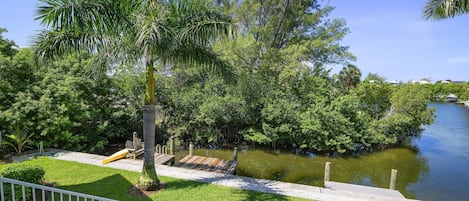 Propiedad frente al agua con muelle, abundante vegetación y vista despejada del agua.