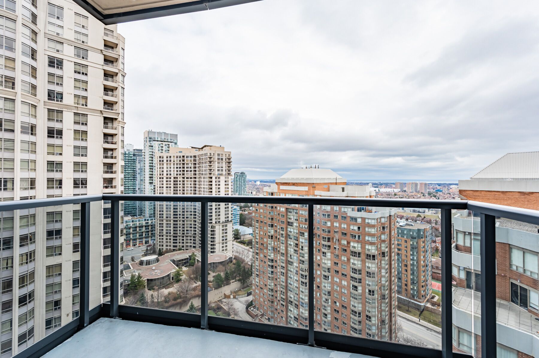A high-rise building with multiple floors and balconies, overlooking a cityscape with various buildings and a dome structure.