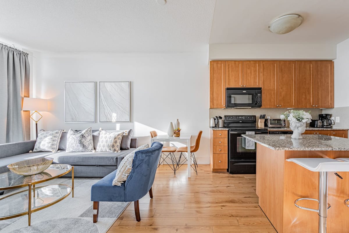 A modern apartment with a living room, dining area, and kitchen.