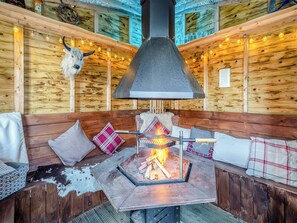 A cozy cabin interior with a central wood-burning stove, wooden walls, and a cow skull decoration. - 2 bedroom accommodation in Hambleton, near Poulton-le-Fylde (Hambleton, near Poulton-le-Fylde)