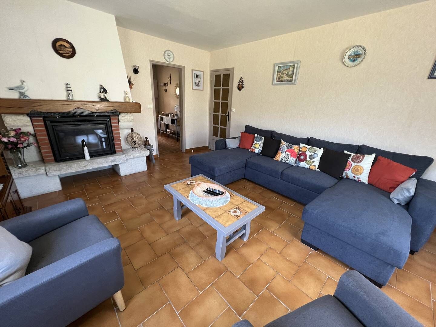 Un salon avec une cheminée, un canapé bleu et une table basse.
