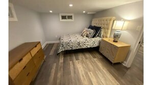 A bedroom with a bed, nightstand, dresser, and a window. - Cheerful 4 bedroom home with all the updates (Newtown)