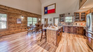 Una cuina àmplia amb una illa gran, armaris de fusta i una bandera de Texas.