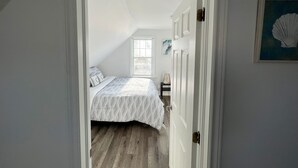 Ein Schlafzimmer mit Bett, Nachttisch und Fenster.
