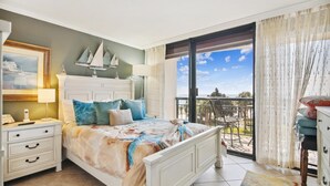 Une chambre à coucher avec un lit, une table de chevet et une commode. Elle dispose d’un balcon avec vue sur la mer.