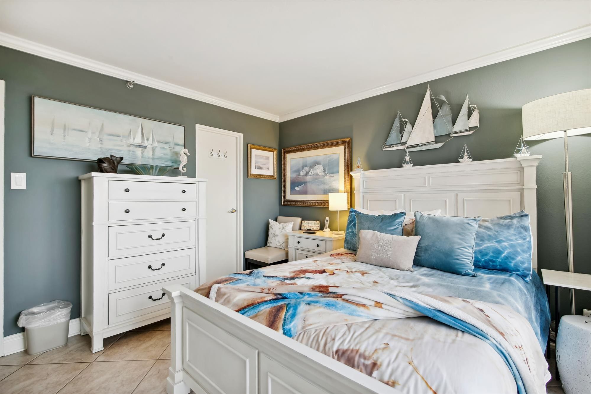 Un dormitorio con cama, cómoda, mesita de noche y decoración en la pared.