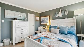 Un dormitorio con cama, cómoda, mesita de noche y decoración en la pared.