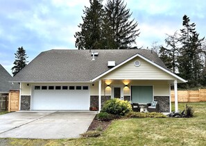 A single-story house with a garage, a covered porch, and a stone accent wall.