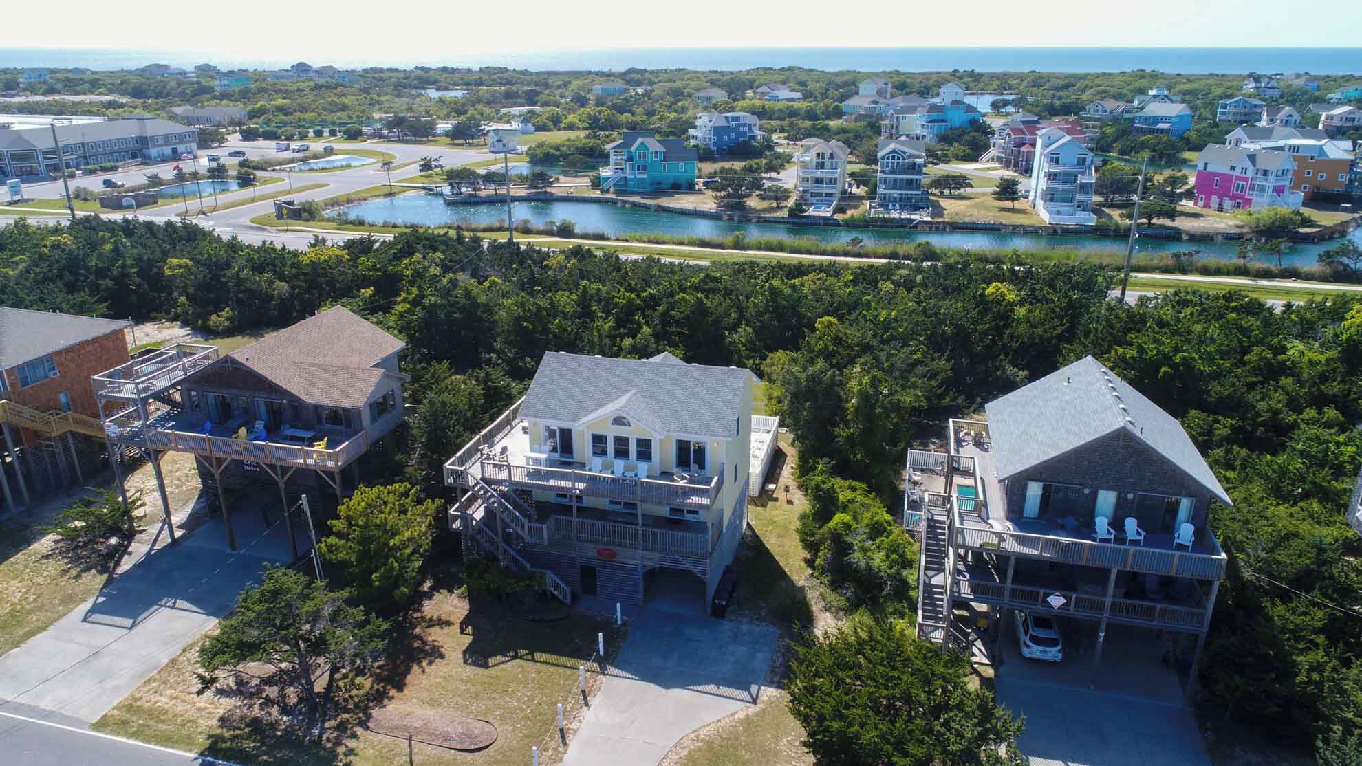 A coastal residential area with houses, a marina, and a road.