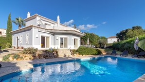 A white villa with a swimming pool, surrounded by greenery and a clear blue sky. - Villa Tranquila - Private swimming pool & stunning gardens, in Presa de Moura (Carvoeiro)