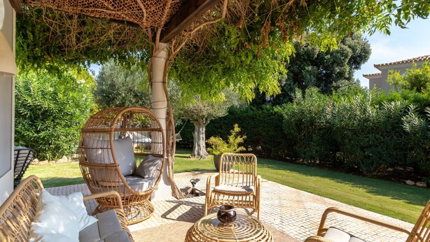 A patio with wicker furniture, including a sofa, chairs, and a round table. - Villa Tranquila - Private swimming pool & stunning gardens, in Presa de Moura (Carvoeiro)