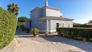 A two-story building with a tiled roof, surrounded by well-maintained hedges and a gravel driveway. - Villa Tranquila - Private swimming pool & stunning gardens, in Presa de Moura (Carvoeiro)