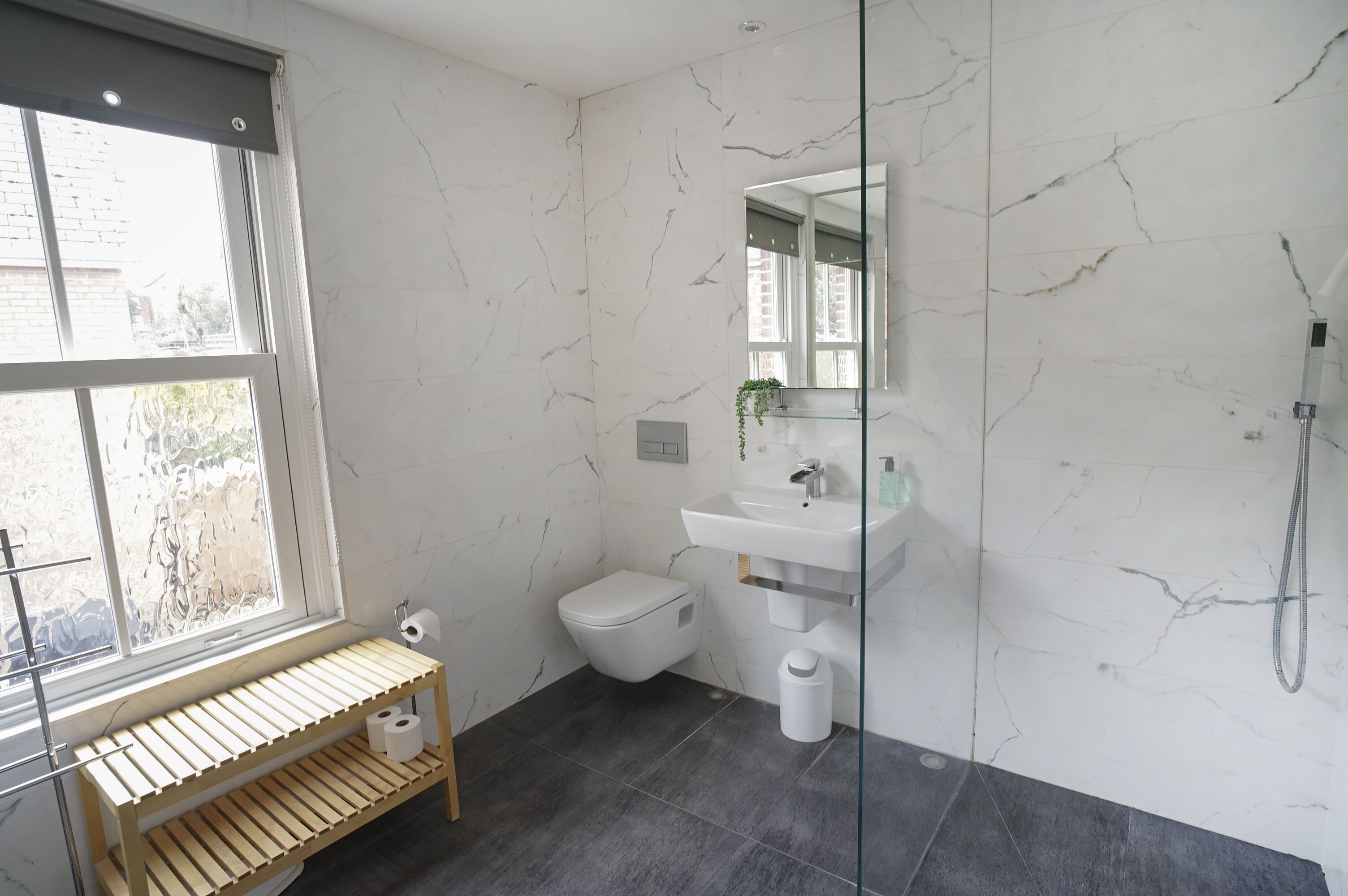 Un baño moderno con inodoro, lavamanos y ducha.