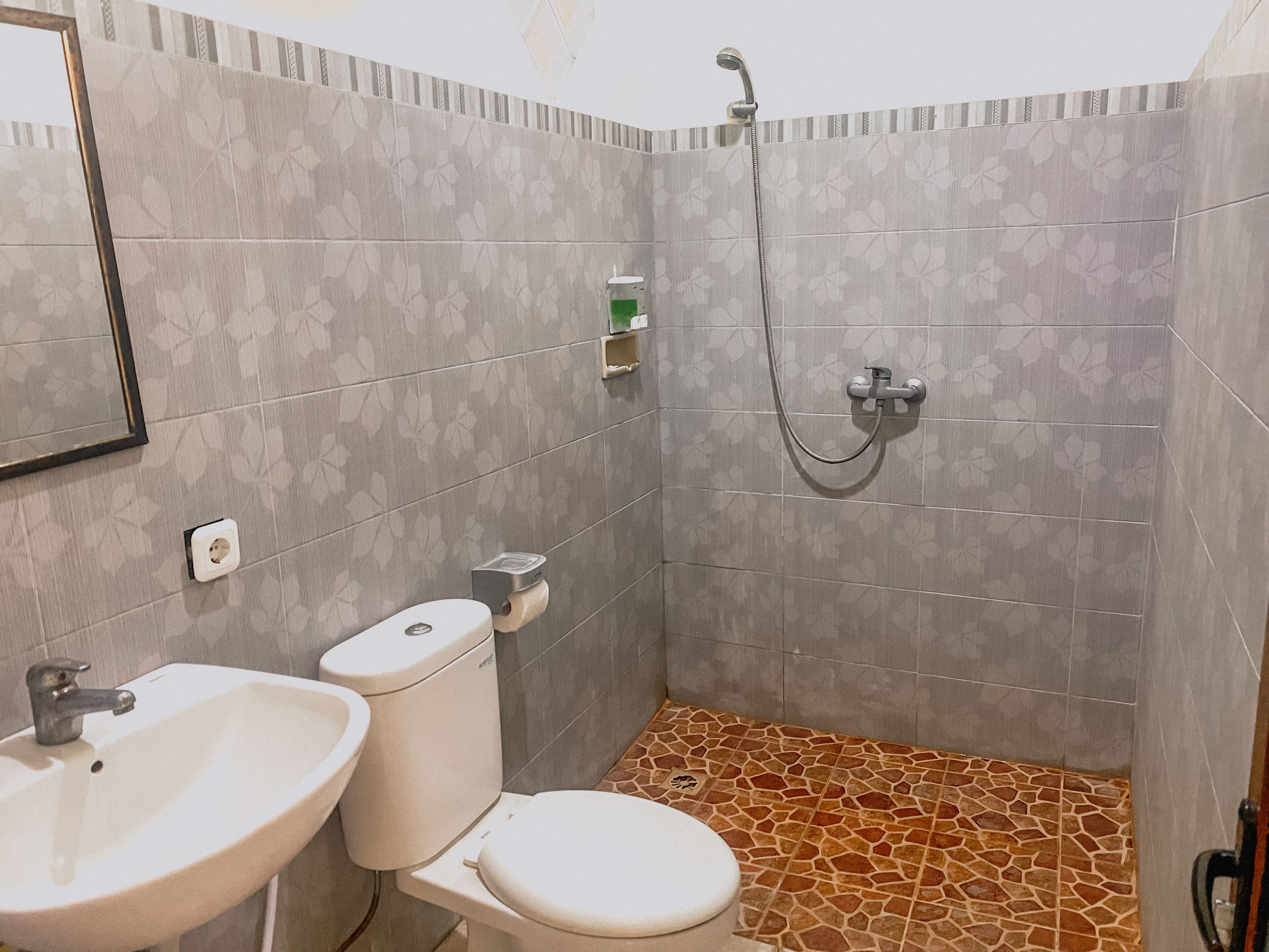 A bathroom with a toilet, sink, and shower.